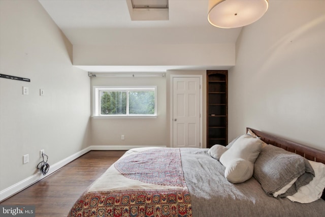 bedroom with dark hardwood / wood-style floors