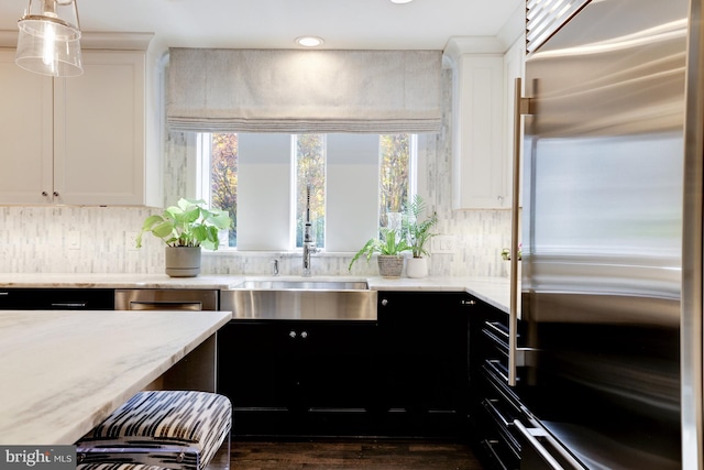 kitchen featuring sink, hanging light fixtures, dark wood-type flooring, high end fridge, and white cabinets