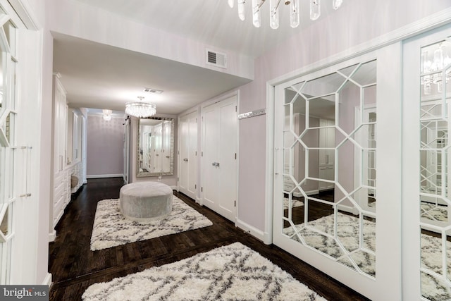 entryway with a notable chandelier and dark hardwood / wood-style flooring