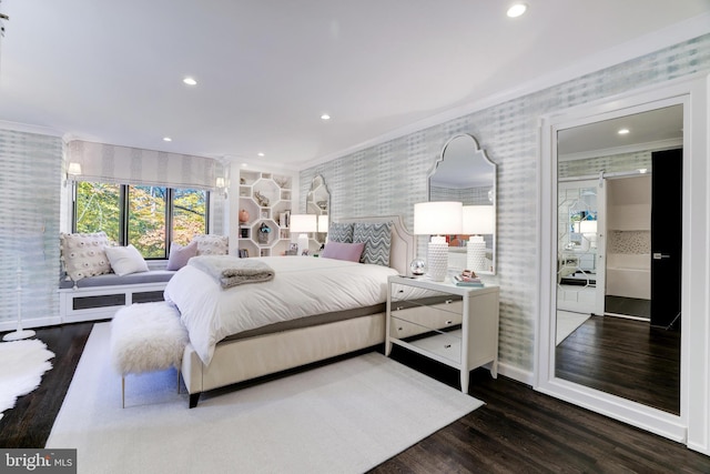 bedroom with dark hardwood / wood-style flooring, crown molding, and connected bathroom