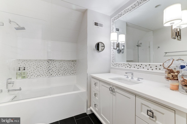 bathroom featuring tile patterned flooring, vanity, and tiled shower / bath