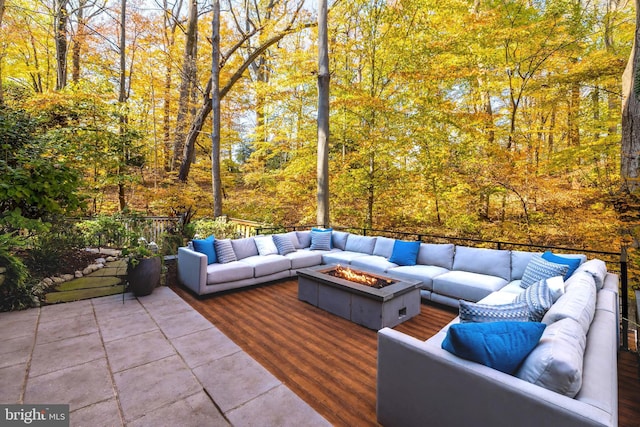 view of patio featuring a deck and an outdoor living space with a fire pit