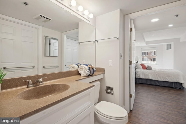 bathroom featuring vanity, hardwood / wood-style floors, and toilet