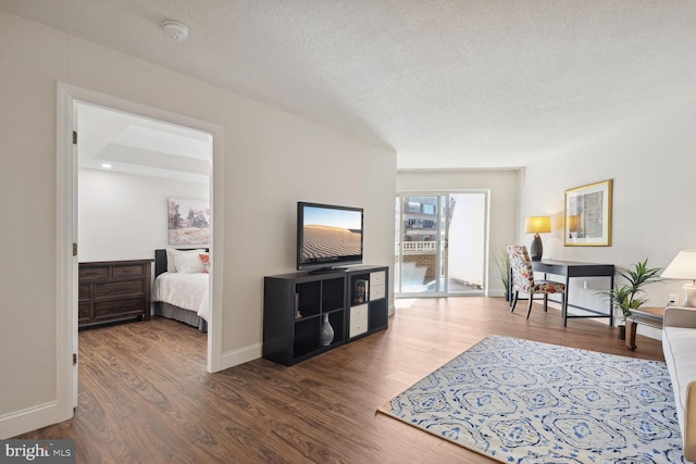 living room featuring a textured ceiling and dark wood-type flooring