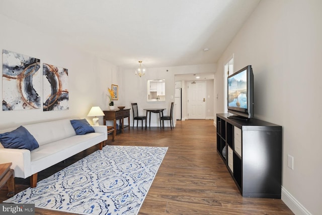 living room featuring an inviting chandelier and dark hardwood / wood-style flooring