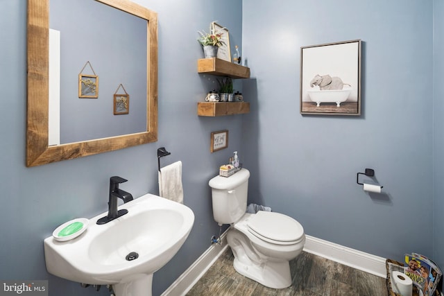 bathroom with toilet, hardwood / wood-style flooring, and sink