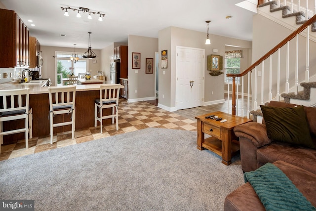 living room featuring sink, an inviting chandelier, and track lighting