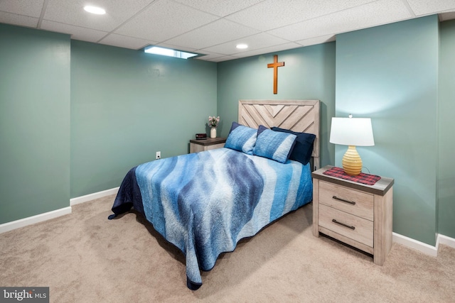 carpeted bedroom featuring a drop ceiling