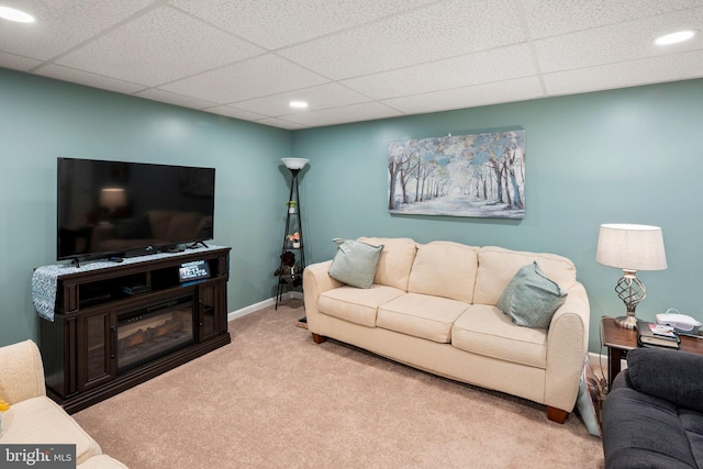 carpeted living room with a paneled ceiling