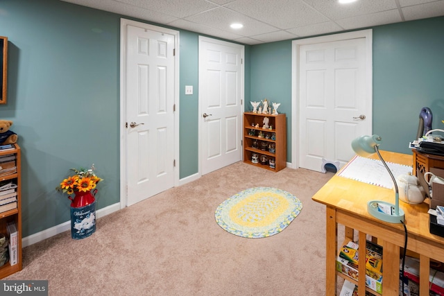 carpeted office with a paneled ceiling