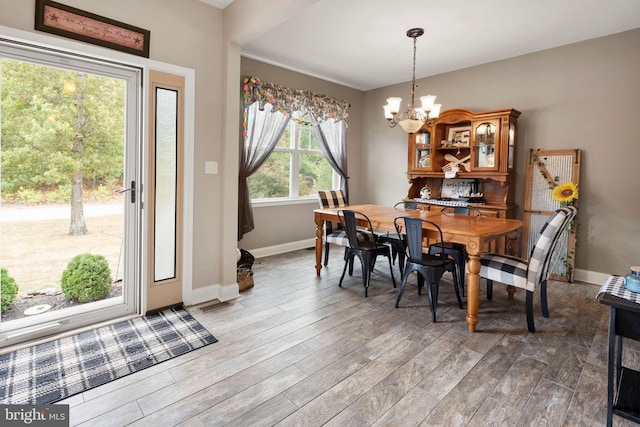 dining space with wood-type flooring and a notable chandelier