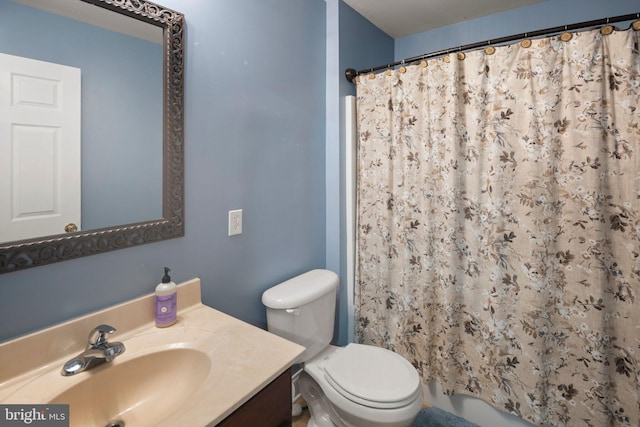 bathroom with curtained shower, vanity, and toilet