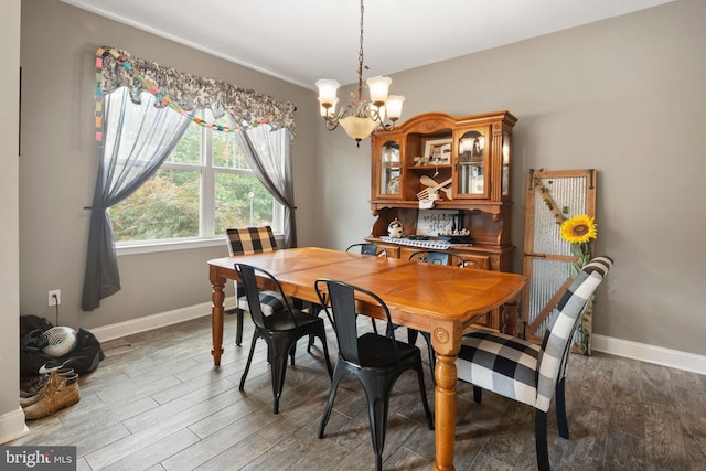 dining space with hardwood / wood-style flooring and an inviting chandelier