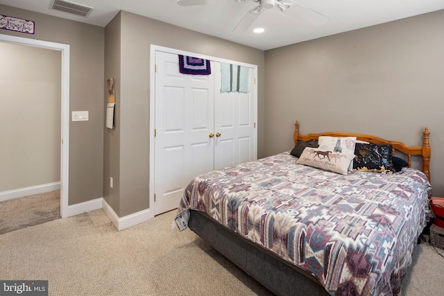 carpeted bedroom featuring ceiling fan and a closet