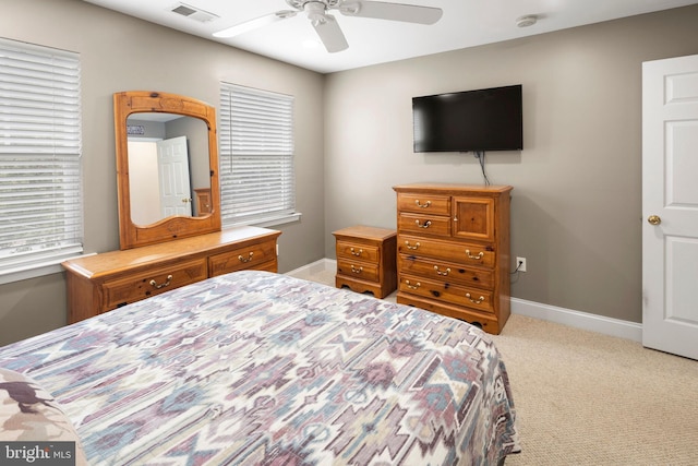 bedroom featuring ceiling fan, multiple windows, and carpet floors