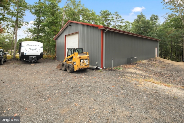 view of outbuilding with central AC unit and a garage