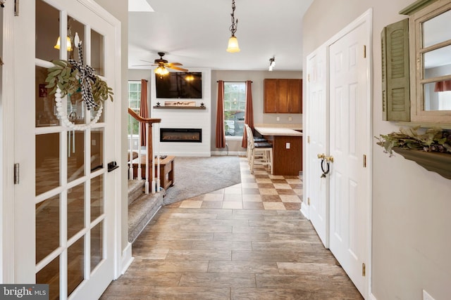 kitchen featuring hanging light fixtures, ceiling fan, and light wood-type flooring