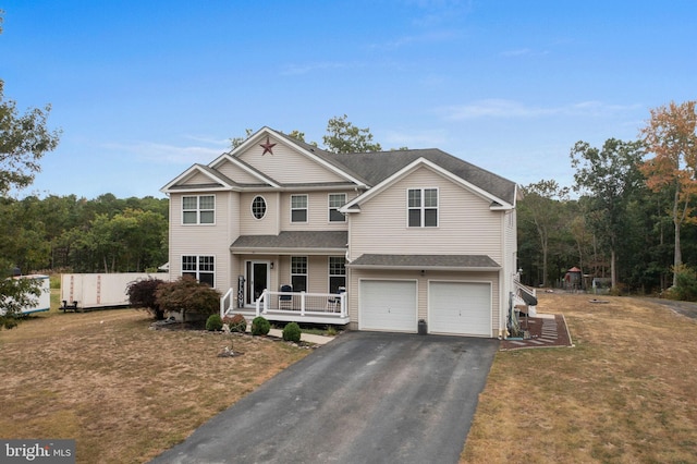 view of front of house with a garage, a front yard, and a porch