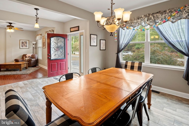 dining room with hardwood / wood-style flooring and ceiling fan with notable chandelier