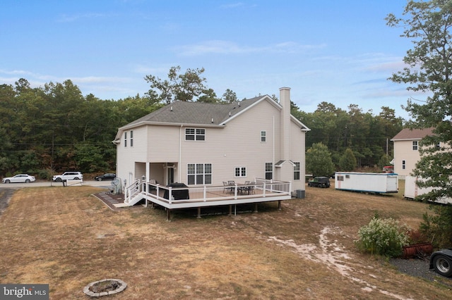 back of house with cooling unit and a deck