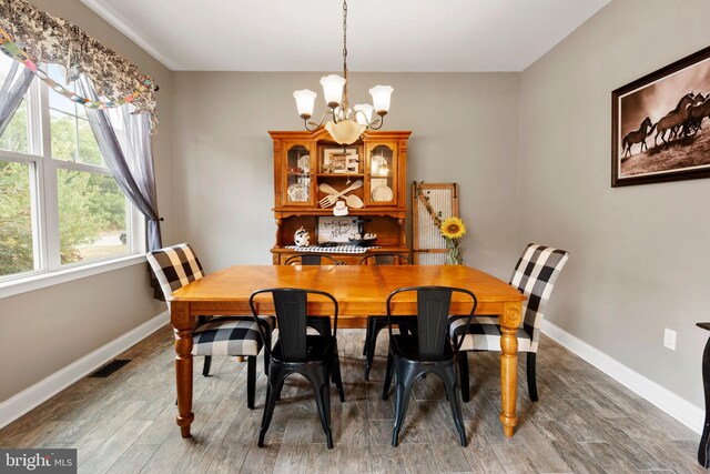 dining space with dark wood-type flooring and a chandelier