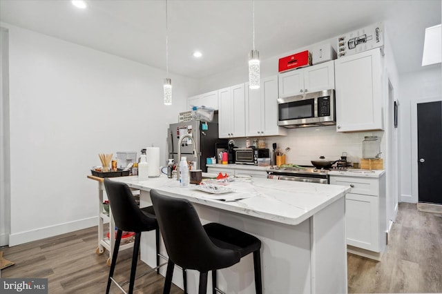 kitchen featuring white cabinets, an island with sink, and appliances with stainless steel finishes