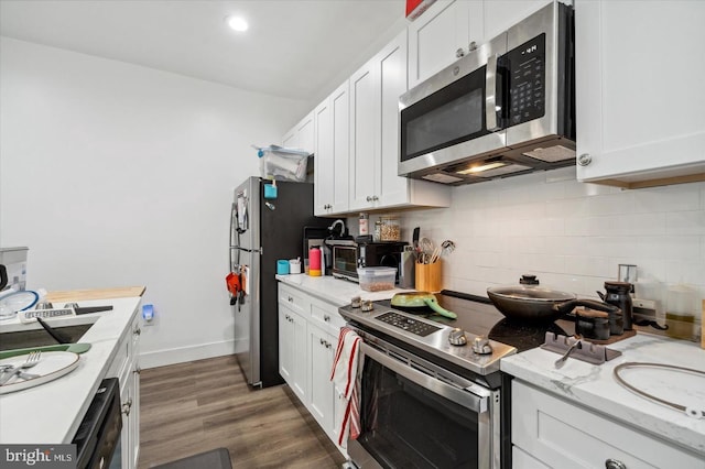 kitchen featuring appliances with stainless steel finishes, white cabinetry, and dark hardwood / wood-style floors