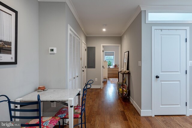 corridor with electric panel, hardwood / wood-style flooring, and ornamental molding