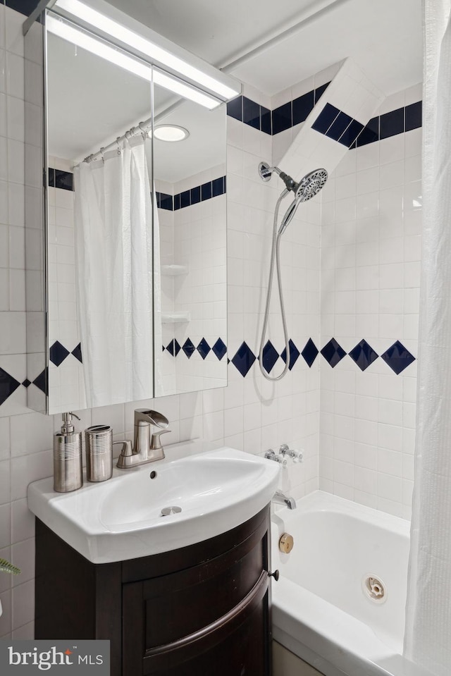 bathroom featuring vanity, tile walls, and shower / bath combo