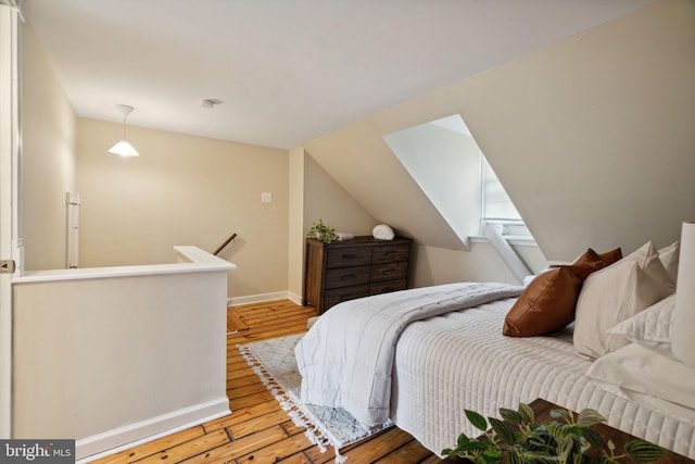 bedroom featuring lofted ceiling and light hardwood / wood-style flooring