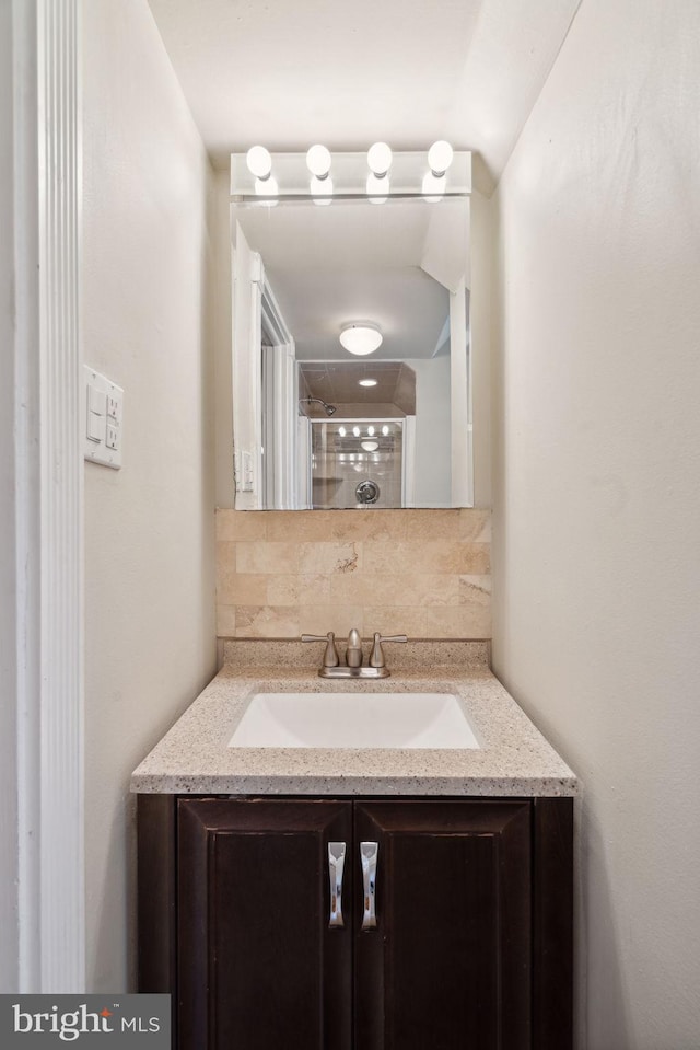 bathroom featuring vanity and tasteful backsplash