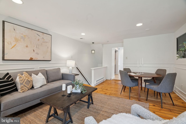 living room featuring baseboard heating and light hardwood / wood-style flooring