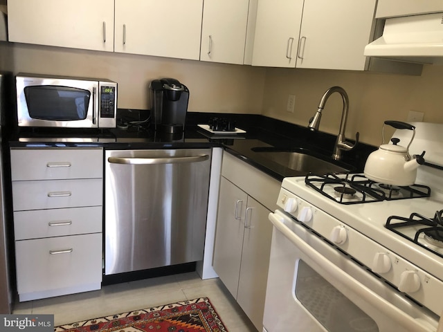 kitchen featuring appliances with stainless steel finishes, white cabinets, extractor fan, and sink