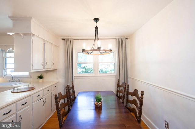 dining area featuring sink, a chandelier, dark wood-type flooring, and plenty of natural light