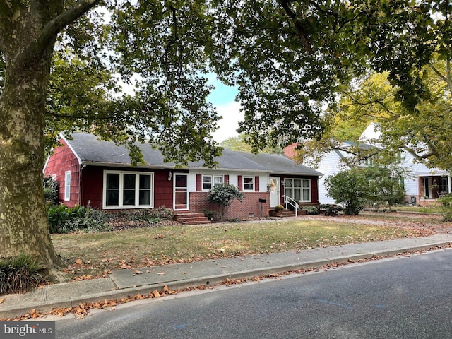 ranch-style home with a front yard, brick siding, and a chimney