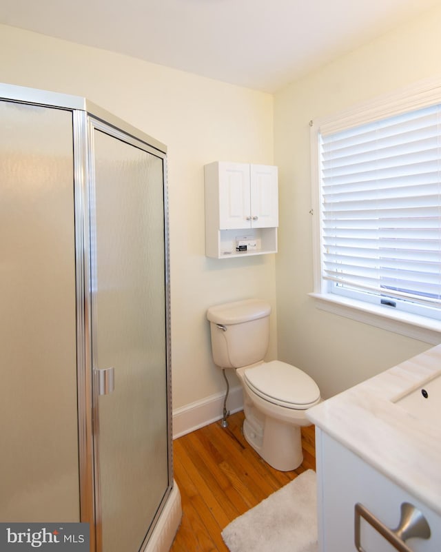 bathroom with vanity, toilet, hardwood / wood-style flooring, and a shower with shower door