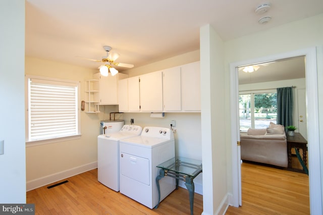 clothes washing area with cabinets, ceiling fan, separate washer and dryer, light wood-type flooring, and water heater