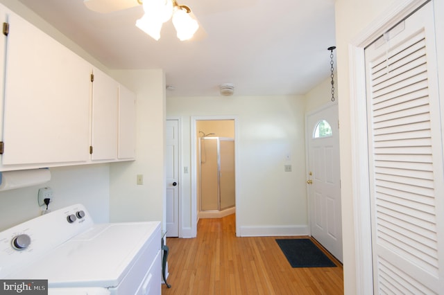 clothes washing area featuring light hardwood / wood-style flooring, cabinets, and independent washer and dryer