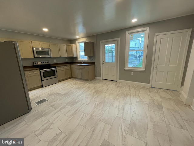 kitchen featuring light brown cabinets, stainless steel appliances, and sink