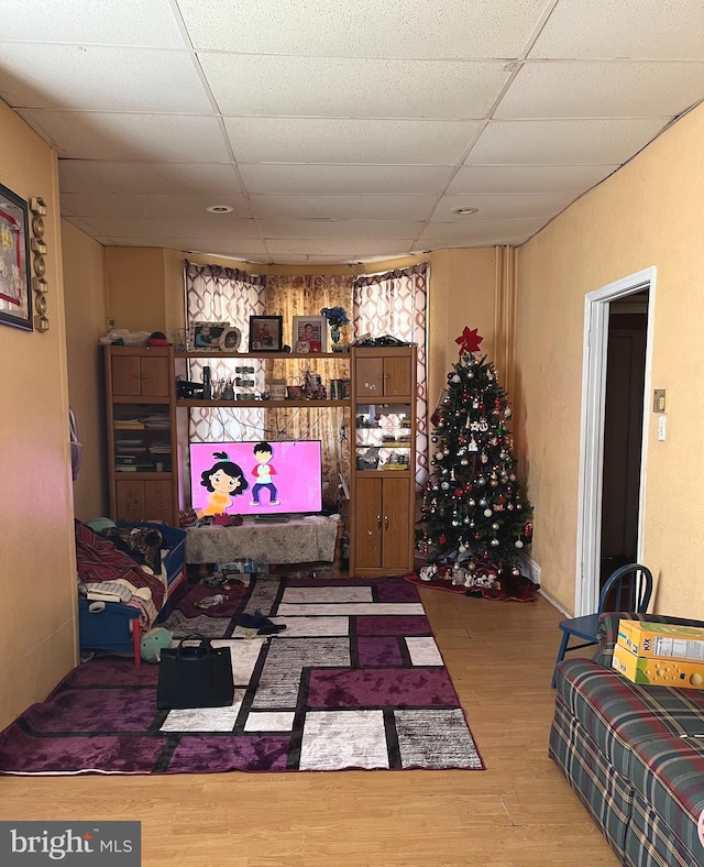 living room with hardwood / wood-style floors and a paneled ceiling