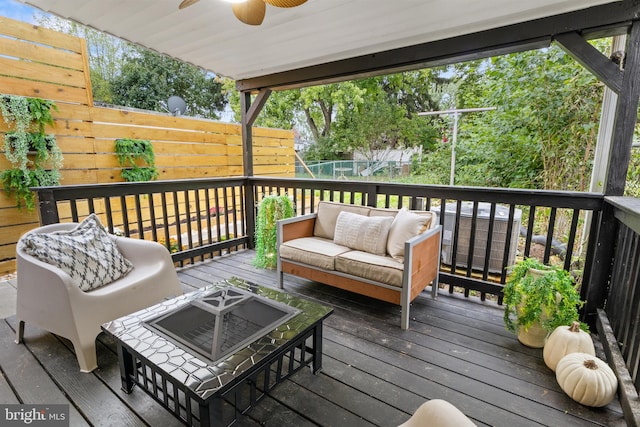 wooden deck with an outdoor living space and ceiling fan