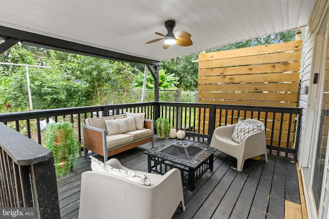 wooden deck featuring outdoor lounge area and ceiling fan