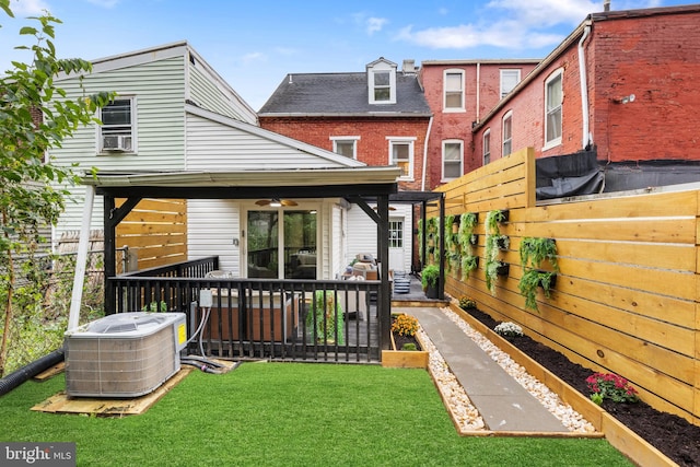 rear view of property with a lawn, cooling unit, and ceiling fan