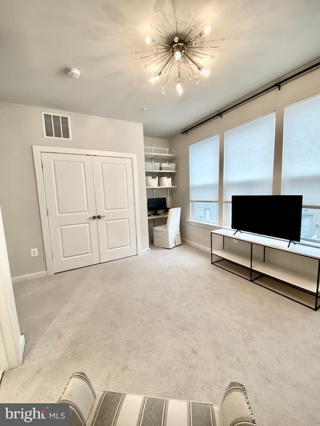 carpeted living room featuring a chandelier