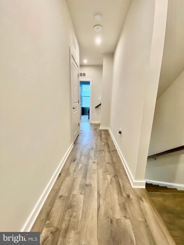 hallway with light hardwood / wood-style floors