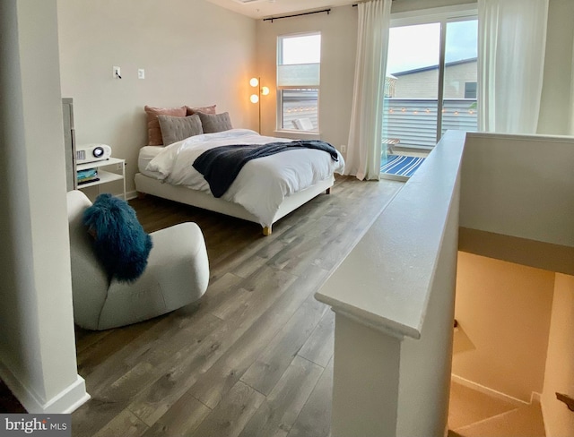 bedroom with access to outside and hardwood / wood-style floors