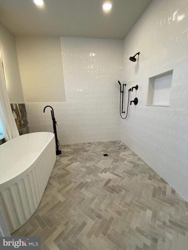 bathroom featuring walk in shower and tile walls