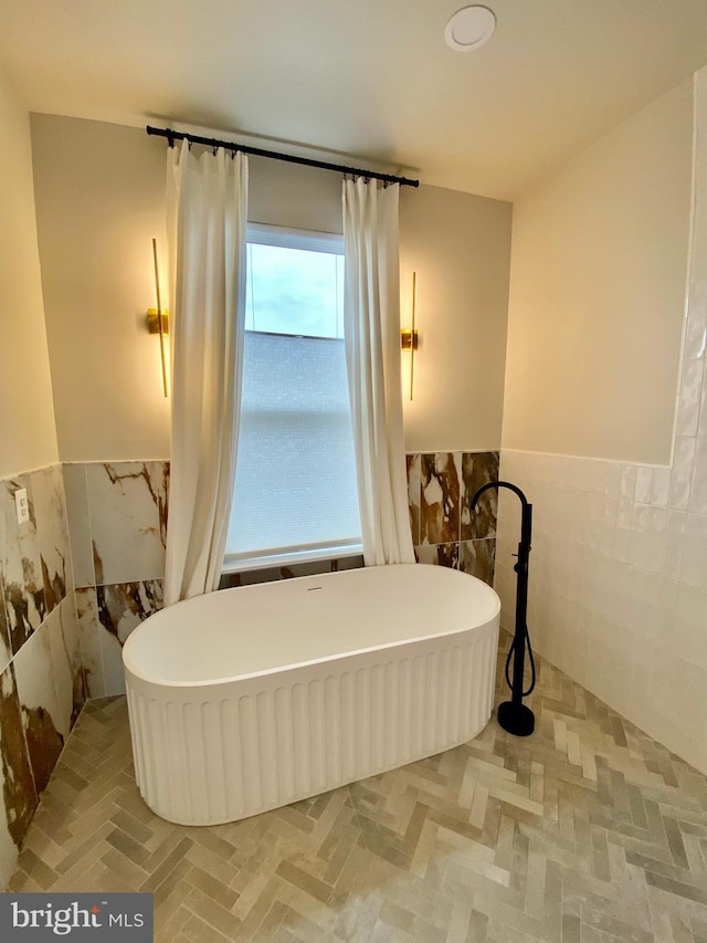 bathroom with tile walls and a tub to relax in