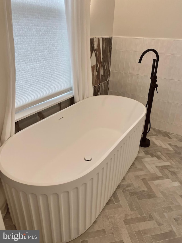 bathroom with tile walls and a bath