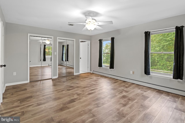 interior space with a healthy amount of sunlight, hardwood / wood-style floors, ceiling fan, and a baseboard radiator